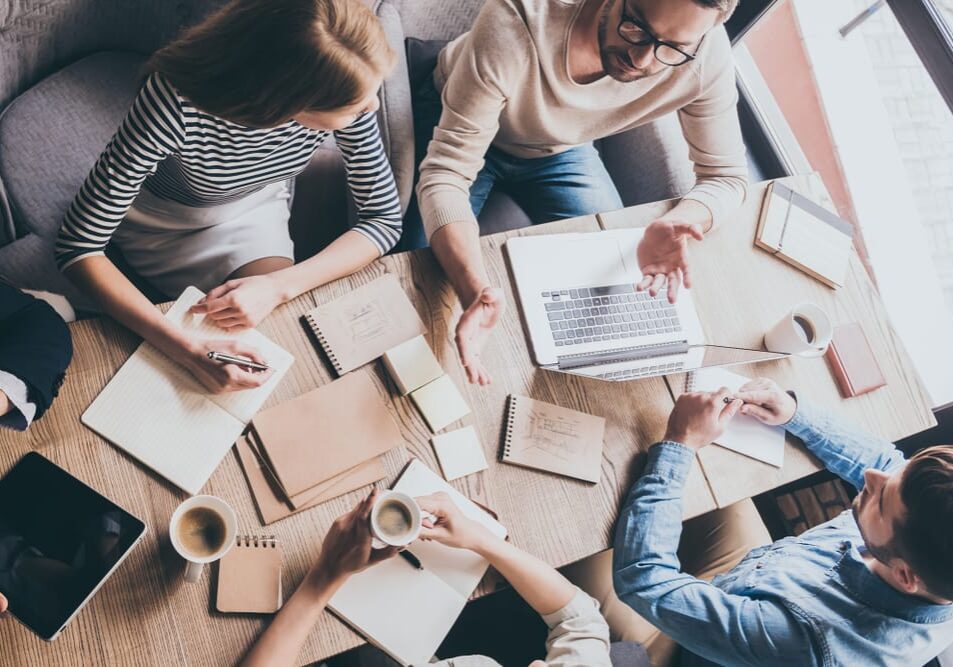 A team of workers brainstorming meeting in a café